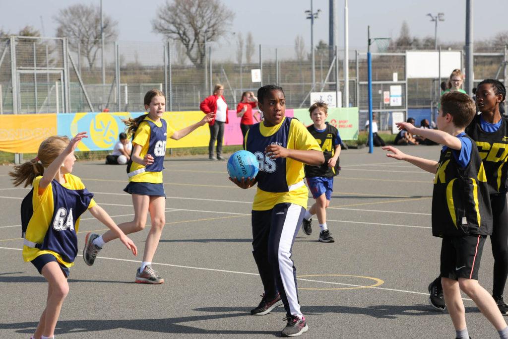 Children playing basketball on a court, dribbling and shooting hoops, having fun and staying active outdoors.