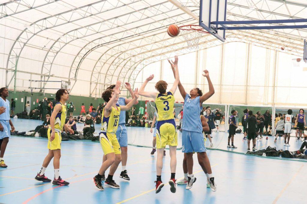 A group of people playing basketball in an indoor arena.