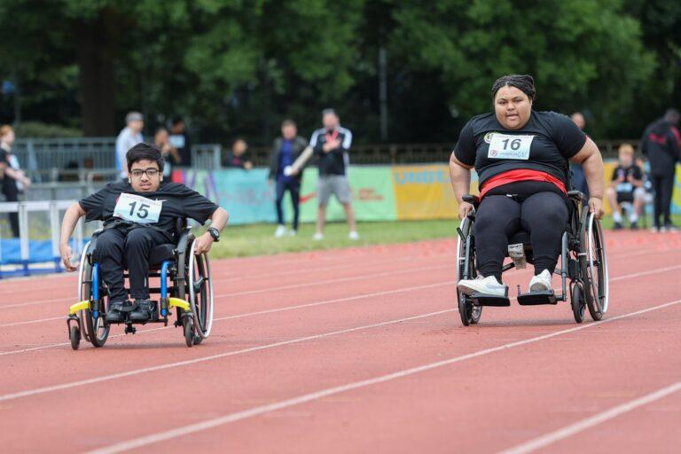 1 brown skinned male wheelchair user and 1 brown skinned female wheelchair user race in athletics event