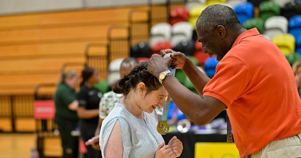 black male gives medal to white female dancer